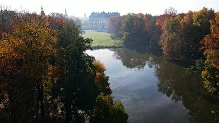 Poster - Scenic view of misty autumn landscape with beautiful old bridge the garden with red maple foliage.