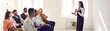 © Studio Romantic - Experienced talented speaker making speech for multiracial audience. Woman standing with microphone and sharing knowledge and skills with multiethnic group of people, side view. Website banner, header