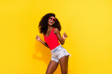 Poster - Photo portrait of dancing girl wearing red singlet shorts sunglass isolated bright yellow color background