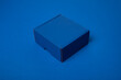 Simple blue cardboard box on color background, top view
