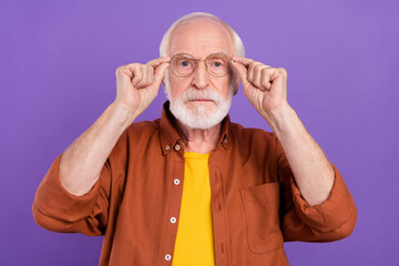 Poster - Photo of strict aged man hands eyewear wearing brown shirt isolated over purple color background