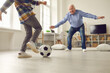 © Studio Romantic - Grandpa and grandson playing soccer at home. Child and grandfather spending time together. Little kid and his grandad having fun. Senior man playing as goalkeeper while playing football with grandkid