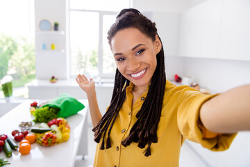 Photo of sweet adorable dark skin woman dressed yellow shirt braids inviting you cooking breakfast smiling indoors house home room