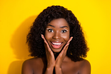 Canvas Print - Photo of young happy excited smiling afro girl wear no clothes apply cream toner on cheeks isolated on yellow color background