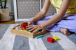 © Дарья Колпакова - Child collects wooden cubes in a tray. Montessori material. Eco Friendly toy
