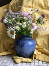 Bouquet Of Wildflowers In The Blue Vase On The Yellow Background