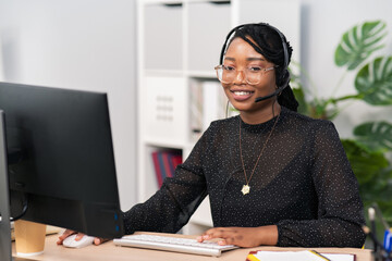 Customer service agent, financial advisor call center employee sits at desk in company in front of computer screen, headphones with microphone on ears, connecting with caller, solving problem