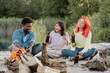 © ABCreative - Friends from different countries erasmus came to study together they spend their free time from studying at common bonfire on beach by lake, drinking beer, talking, singing, joking, fooling around