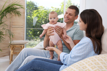 Wall Mural - Happy family with their cute baby in living room at home