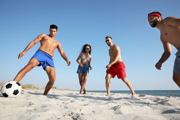 Wall Mural - Group of friends playing football on beach