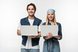 © LIGHTFIELD STUDIOS - happy couple wearing denim clothes and holding laptops isolated on white