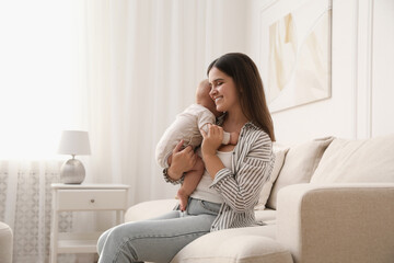 Wall Mural - Young woman with her little baby on sofa at home