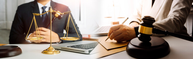 Business and lawyers discussing contract papers with brass scale on desk in office. Law, legal services, advice, justice and law concept picture with film grain effect