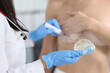 Plastic surgeon holding silicone breast implant and applying preoperative markings to patient chest closeup