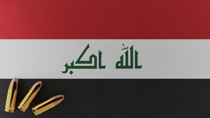 Three 9mm bullets in the bottom left corner on top of the national flag of Iraq