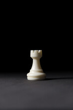 Isolated White Rook Chess Piece On Black Background.