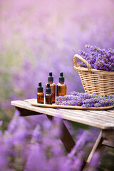 Wall Mural - Essential lavender oil in the bottle with dropper on the gray wooden desk. Horizontal close-up.