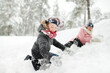© MNStudio - Two young girls having fun together in beautiful winter park. Cute sisters playing in a snow. Winter activities for family with kids.