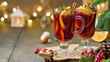 Two glasses of hot red mulled wine beverages with cardamom, cinnamon, clove, orange, anise, cranberry, fir needles. Seasonal winter beverage. Christmas decor. Selective focus, blurred background