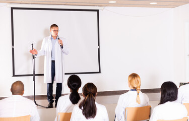 Sticker - Portrait of confident male medical coach giving speech at conference for health workers