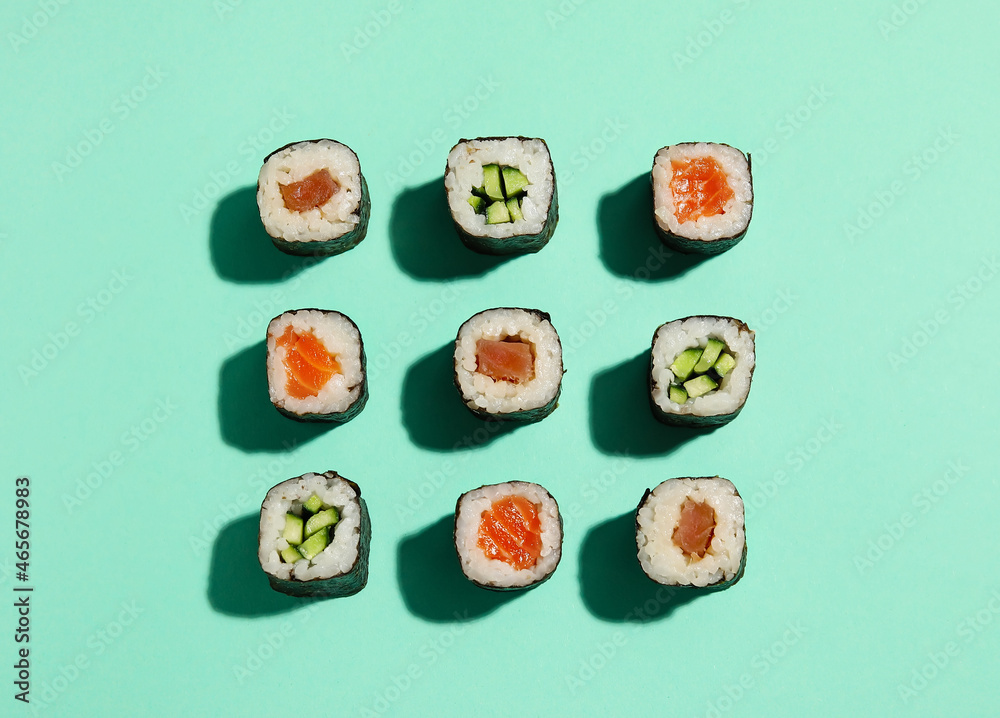 Delicious cucumber and salmon maki sushi on color background