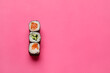 Delicious salmon and cucumber maki sushi on color background