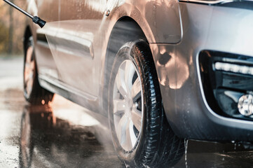 Canvas Print - Manual car wash with white soap, foam on the body. Washing Car Using High Pressure Water.