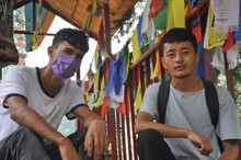 Two Male Friends Looking At Camera With Sitting On Stairs Of Buddhist Temple In Tso Pema During Covid-19 Pandemic 