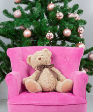 Teddy Bear Sitting In Pink Armchair In Background Christmas Tree