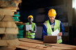 © Drazen - Warehouse foreman works on laptop at wood distribution compartment.