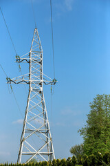 high voltage power lines against the blue sky in the city. high voltage electric pole