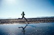 Woman trail runner running in winter lakeside
