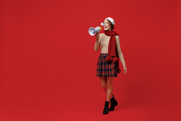 Wall Mural - Full body young woman in Santa Claus Christmas hat hold scream in megaphone announces discounts sale Hurry up isolated on plain red background studio portrait. Happy New Year 2022 celebration concept.