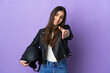 © luismolinero - Young caucasian woman with a motorcycle helmet isolated on purple background shaking hands for closing a good deal
