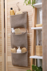 Poster - Storage with essentials hanging on wooden folding screen in bathroom. Stylish accessory