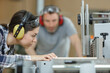 © auremar - carpenter training female apprentice in workshop