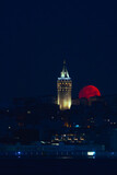 Fototapeta Londyn - Galata Tower at moonset in Istanbul. Istanbul story background photo. Travel to Turkey. Ramadan, kandil, iftar, laylat al-qadr, islamic new year, eid mubarak background photo.