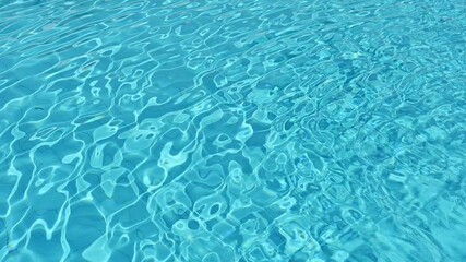 Wall Mural - Water rippled surface of swimming pool with sunlight reflection