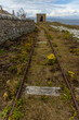 Outside views of older derelict coastguard lighthouse buildings and old rail tracks on Ailsa Craig Island, Scotland
