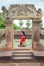 Portrait Asian Woman In Thai Tradition Clothing Sitting In Front Of The Gate Side A Lotus Pond In Prasat Muang Tam, Prasat Muang Tam Is A Khmer Hindu Temple In Buriram Province, Thailand