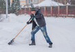 © T.Den_Team - Winter, people and snow problem concept - man digging snow with shovel at yard. Man standing with blue shovel, cleaning.