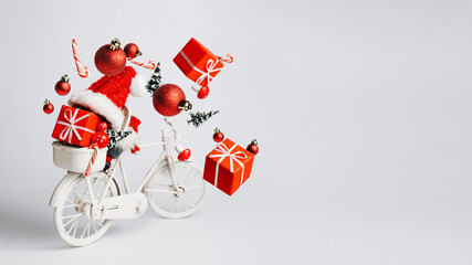 Wall Mural - Christmas composition with retro bicycle with red gifts and presents flying out of basket on bright white background. Creative Xmas delivery concept. New year shopping banner with copy space.