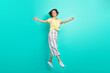 Full size profile side photo of young girl happy positive smile jump go open arms welcome isolated over teal color background