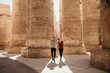 Leinwandbild Motiv Traveling couple walking through Karnak temple in Luxor Egypt 