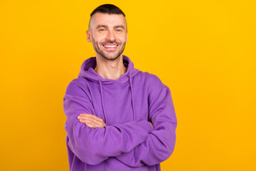 Canvas Print - Photo of optimistic millennial brunet guy crossed arms wear violet hoodie isolated on yellow color background