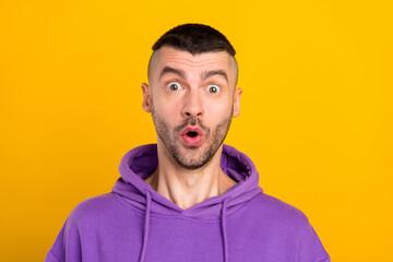 Wall Mural - Photo of impressed young brunet guy wear violet hoodie isolated on yellow color background