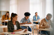 © Drazen - Mid adult black student and her classmates write an exam while attending class at lecture hall.