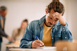 © Drazen - Mid adult student doing an exam at university classroom.