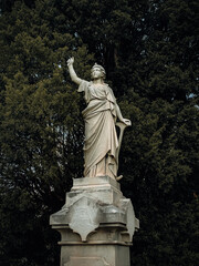 Poster - Vertical shot of a statue of a woman holding an anchor at the historic cemetery of Oakland