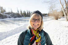 Portrait Happy Senior Woman In Sunny Snowy Winter Park